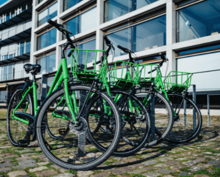 Four green bicycles in front of building