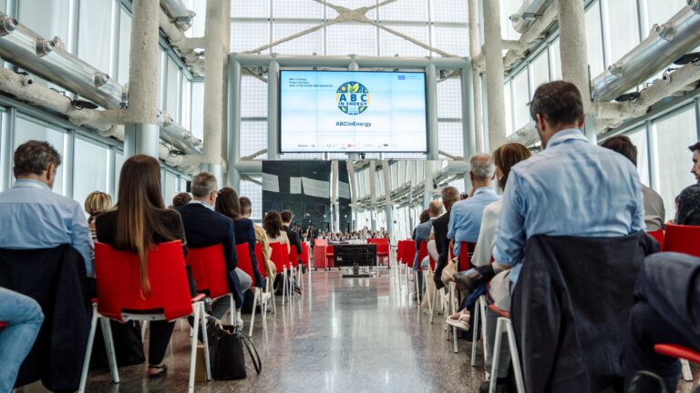 People sitting in front of a presentation screen at a conference
